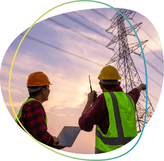 two men with hardhats pointing towards electric utility pole