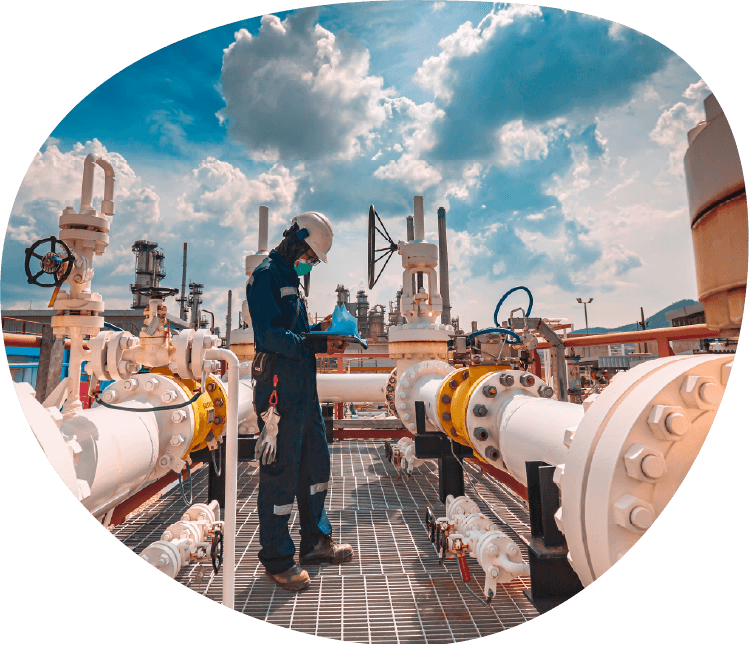 oil and rig pipeline on-site with a field worker standing