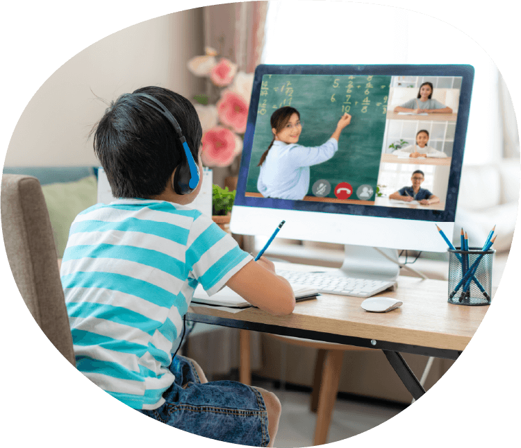 Elementary student at home watching a teacher share a lesson virtually.