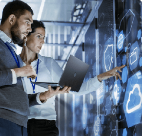 two people with a laptop pointing at digital screen with cloud and security symbols