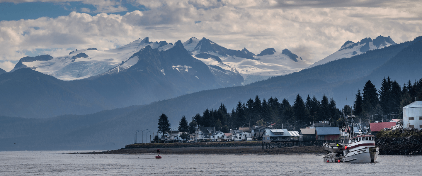 A body of water surrounded by houses and mountains